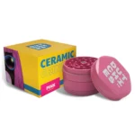 En keramisk kværn præsenterer sig i en blød pink nuance med en glat overflade. Den har en cylindrisk form, der måler 62 mm i diameter. Toppen er flad med en let buet kant, mens bunden har en skridsikker tekstur. Kværnen har små åbninger ved bunden, som muliggør en jævn distribution af materialet.