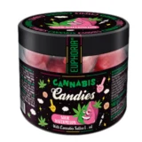 Farverne domineres af en lys grøn og pink nuance, der skaber en livlig kontrast. De små, runde slikstykker har en glat overflade med en let glinsende tekstur. Hver candy er prydet med et bølget mønster, hvilket giver dem en indbydende og appetitlig fremtoning. Indpakningen er farverig og præsenterer tydeligt produktets navn og smagsvariant.