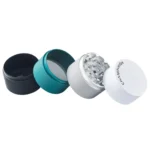 En højt, cylindrisk kværn med en diameter på 63 mm præsenterer sig med en børstet metaloverflade, der har en sølvgrå nuance. Øverste del er udstyret med en skrueknap, mens den nederste del har en perforeret skive til malet materiale. Kværnen har glatte kanter og en minimalistisk, moderne design, der fremhæver funktionalitet.