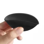 En lille skål med en diameter på 7 cm, udført i silikone. Skålen har en dyb sort farve på ydersiden, mens indersiden er lyserød. Den har en glat tekstur, der giver et moderne udtryk. Skålen har en blød, fleksibel form, hvilket gør det nemt at presse indholdet ud. Der er ingen synlige knapper eller symboler.