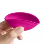 En lille blandeskål i silikone, der måler 7 cm i diameter. Skålen er delt op i en lyserød og en sort sektion, hvilket giver en kontrast mellem de to farver. Overfladen er glat og skinnende, hvilket fremhæver silikonematerialets fleksibilitet. Den runde form har en lav kant, og skålen er let at håndtere.