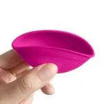 En lille skål i silikone med en diameter på 7 cm, prydet med en blød rosa farve og hvide indslag. Skålen har en glat overflade med let fleksible kanter, der bøjer ved tryk. Den har en rund bund, hvilket giver stabilitet, og de ensartede farver skaber et enkelt, men stilfuldt udtryk.