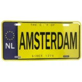 Et metal skilt med en rektangulær form, domineret af en hvid baggrund. Øverst ses teksten "Amsterdam" i store, sorte bogstaver. Under teksten er der en grafisk illustration af en bysilhuet og farverige ikoner, der fremkalder en livlig atmosfære. Kanterne er let afrundede, og overfladen har en glat, skinnende finish, der reflekterer lys.