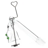 En klar, gennemsigtig glasskål med en glat overflade og en let buet form. Skålen har en bred åbning og en dyb bund, der giver plads til væske. Håndtaget er langstrakt og buet, hvilket giver et ergonomisk greb. Den enkle, minimalistiske stil fremhæver det moderne design, og kanterne er skarpt definerede uden ornamentik.