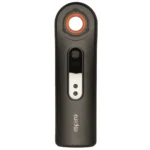 En slank, cylindrisk enhed med en glat metaloverflade pryder midten, mens en sort adapter med en lille åbning er placeret i den ene ende. En tydelig, buet form sikrer ergonomisk greb. Overfladen har en poleret finish, der reflekterer lys, og en lille knap er synlig, måske til regulering, hvilket giver en minimalistisk og elegant æstetik.