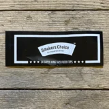 Klistermærket har en sort baggrund med en glat tekstur. I midten står teksten "Smokers Choice" i en fremtrædende, hvid skrifttype. Omkring teksten er der en tynd, hvid kant, der fremhæver logoet. Klistermærket har en oval form, hvilket giver det et kompakt udseende, der er let at påføre.