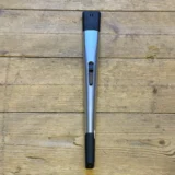 En lang, slank lighter pryder overfladen med en glat, metallisk finish. Farven er en dyb blå, der skinner let i lyset. Lighterens top har en lille, rund knap til tænding, mens der er en synlig genopfyldningsport i bunden. Der er også en beskyttende låg, der dækker tændingsmekanismen, hvilket tilføjer funktionalitet til designet.
