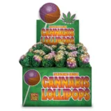 En række farverige lollipops pryder overfladen med en glinsende, gennemsigtig finish. Lollipops har en rund, flad form med en tydelig stang, der er let buet. Farverne spænder fra dyb orange til lys gul, med et marmoreret mønster, der giver et friskt og indbydende udseende. Overfladen er glat, og refleksionerne tilføjer en livlig dimension.