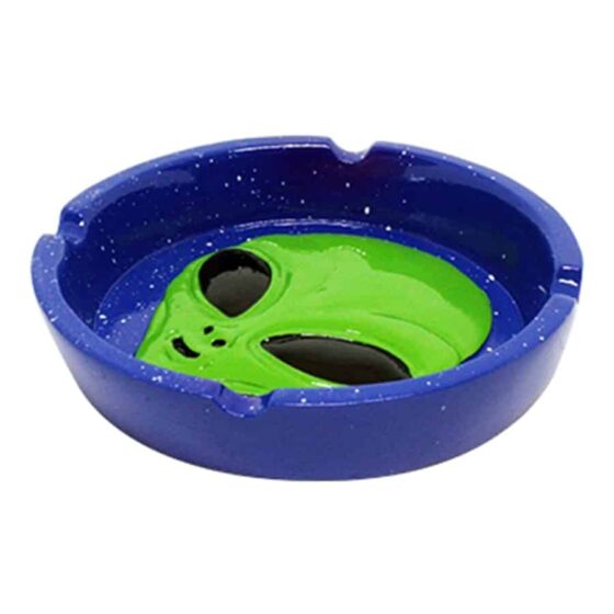 Et askebæger i form af en alien, fremstillet af glat resin med en blank overflade. Farven er en dyb grøn nuanceret med detaljer i mørkere og lysere grønne toner. De karakteristiske træk omfatter store, ovale øjne og en flad bund, som sikrer stabilitet. Mønsteret på overfladen tilføjer en interessant tekstur, der fanger opmærksomheden.