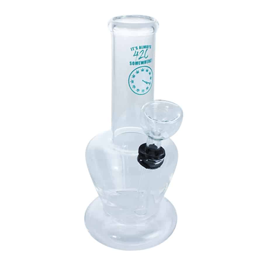 En bongs slanke, cylindriske form fremstår i klart glas med en let grønlig nuance. Den har en solid, rund fod, der sikrer stabilitet. På toppen er der en buet hals, der fører til et mundstykke. Indvendigt ses en indbygget perkolator, der skaber flere lag af bobler. Det samlede design er elegant og funktionelt.