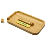 Bamboo tray i naturlig træfarve præsenterer en glat overflade med let buede kanter. Det har en rektangulær form og synlige åretegninger, der giver en organisk tekstur. Trayens hjørner er let afrundede, og den har en mat finish. Ingen synlige indgraveringer eller dekorationer er til stede, hvilket understreger det enkle design.