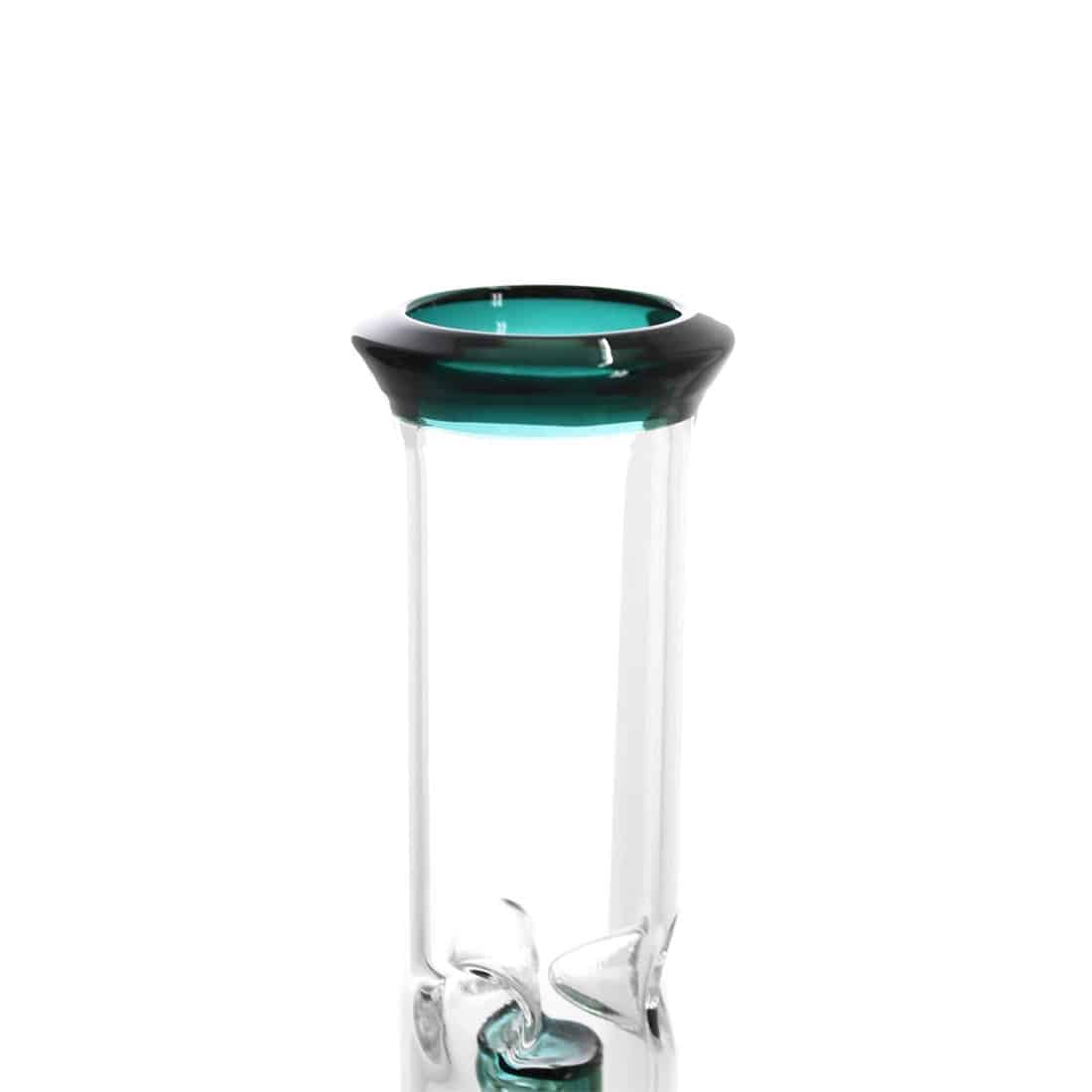 En beaker i klart glas har en cylindrisk form med en bred åbning og en flad bund. Den er fyldt med en dyb petrolblå væske, som reflekterer lyset og skaber en glinsende overflade. Beakeren har en tydelig måleskala på siden, med sorte markeringer, der angiver volumen. Kanten er glat, og der er en let buet overgang til bunden.
