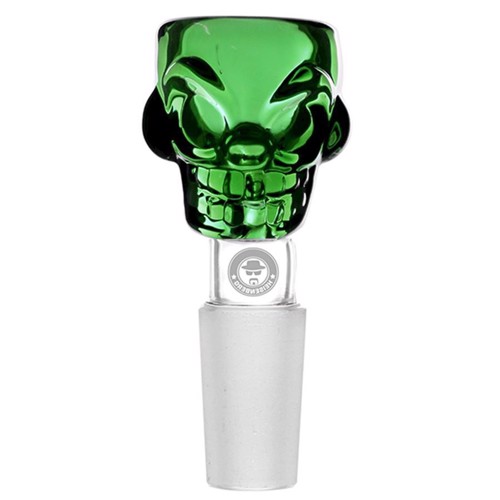 En skål i form af et kranium, udført i en klar grøn farve, præsenterer en glat, skinnende overflade. Skålen har detaljerede ansigtstræk, herunder dybe øjenhuler og en markant kæbelinje. Den buede form giver en dramatisk, tredimensionel effekt. Indvendigt er skålen glat, mens ydersiden viser en struktureret overflade med skarpe kanter og tydelige konturer.