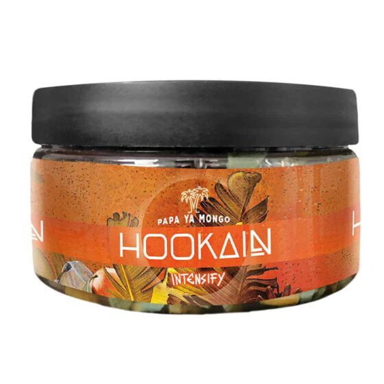 En pakke med tobaksfrie urter præsenterer sig i en rektangulær form, indpakket i en farverig folie. Forsiden viser en grafisk illustration af en mango, omgivet af grønne blade. Teksten "Hookain Intensify" fremhæves i store, kontrasterende bogstaver. Farverne spænder over nuancer af orange, grøn og sort, hvilket skaber en livlig visuel effekt. Pakken indeholder 100 gram.