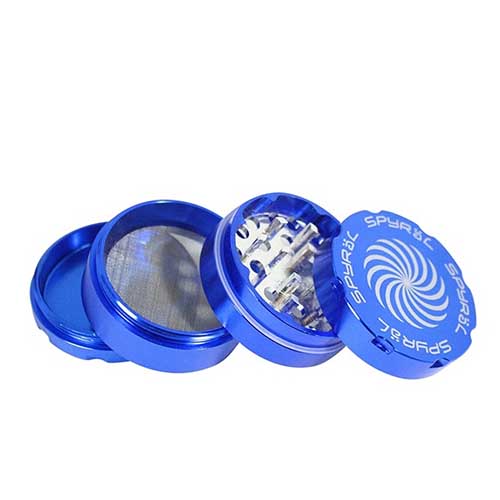 En fire-lags krydderigrinder med en diameter på 55 mm præsenterer sig i en klar blå farve. Den har en glat, cylindrisk form med en skridsikker overflade. Toppen har en lille åbning til påfyldning, mens bunden er udstyret med små perforeringer. Grinderen har en transparent sektion, der giver indblik til det indhold, der er gemt indeni.