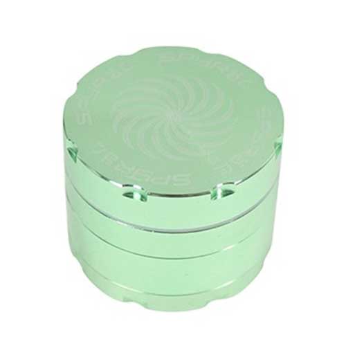 En grøn krydderi-grinder i fire lag præsenterer sig med en glat, mat overflade. Den er cylindrisk med en diameter på 55 mm og har en skridsikker struktur. Øverste del indeholder et skruelåg med en let tilgængelig åbning. Indvendigt ses skarpe, diamantformede tænder til effektiv maling af krydderier samt et fint net, der separerer det malede indhold.