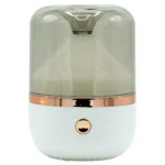 En aroma diffuser i hvid og bronze farve pryder overfladen. Den har en glat, oval form med en hvid, mat finish og en bronze ring, der adskiller de to farver. Diffuseren har en diskret LED-indikator og små lufthuller, der giver mulighed for dampudslip. Materialet fremstår som plastik, med en glinsende overflade på den bronze del.