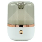 En aroma diffuser i hvid og bronze farve pryder overfladen. Den har en glat, oval form med en hvid, mat finish og en bronze ring, der adskiller de to farver. Diffuseren har en diskret LED-indikator og små lufthuller, der giver mulighed for dampudslip. Materialet fremstår som plastik, med en glinsende overflade på den bronze del.