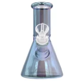 En bongs cylindriske form er fremstillet af klart glas med en iriserende blå overflade, der skaber en skiftende farveeffekt. Den har en bred, stabil bund og en slank hals, der afsluttes med en udskæring. En lille skål er anbragt på siden, og der er en åbning i bunden til vand, hvilket tilføjer funktionalitet til designet.