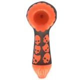 Et sort fåreskull pryder en orange rørformet base, som giver en kontrast til den matte overflade. Skullens detaljerede tekstur fremhæver knoglestrukturen, mens de glatte linjer på røret skaber en moderne æstetik. Farverne interagerer dynamisk, hvilket gør objektet iøjnefaldende og unikt. Placeringen af skull og rør er velafbalanceret.