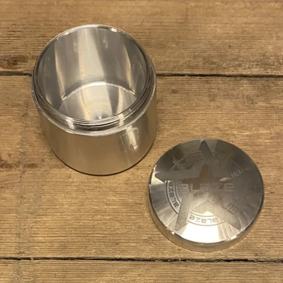 Glasbeholderen præsenterer en cylindrisk form med en klar, glat overflade, der afslører indholdets farver. Låget er lavet af lyst træ, med en silhuet i en let buet form, der passer tæt til åbningen. Beholderens bund er flad, hvilket giver stabilitet. Mønstre på overfladen er fraværende, hvilket fremhæver det minimalistiske design.