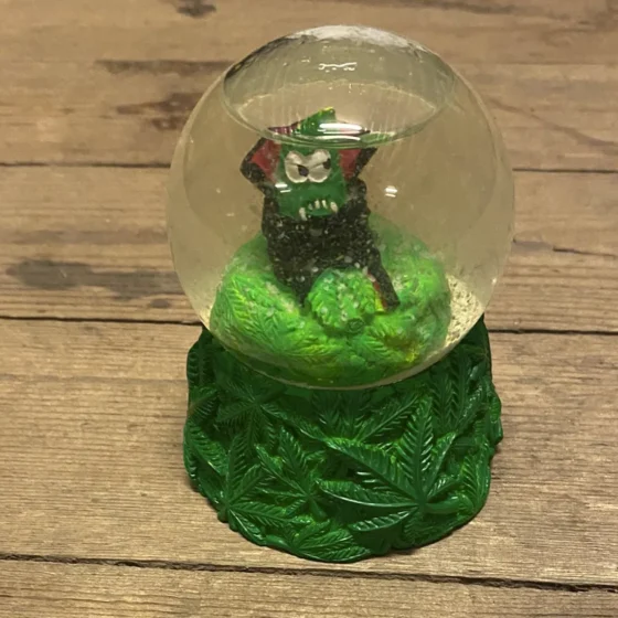 En juletræskugle i klar glas prydet med en glitrende, sølvfarvet overflade. Kuglen har en rund form med en diameter på cirka 10 centimeter. Den er dekoreret med fine, hvide snefnug og små stjerner, der skaber et festligt mønster. En tynd, sølvfarvet snor er fastgjort til toppen, hvilket muliggør ophængning.