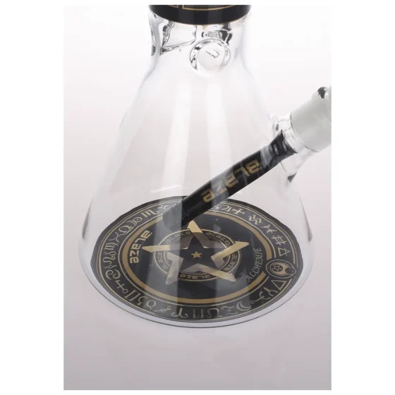 En højtstående bong i klart glas, præget af en slank, cylindrisk form. Øverst findes en bred skål med detaljeret mønster, der skaber en kontrast til den glatte overflade. I bunden ses en robust, rund fod, der giver stabilitet. Farven er gennemsigtig med lette reflekterende nuancer, der fremhæver den glatte tekstur og de rene linjer.