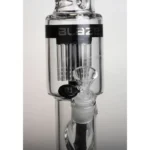 En 48 cm høj bong med en slank, cylindrisk form. Den er lavet af klart glas, hvilket giver et gennemskueligt udseende. Øverste del har en bred åbning med en afrundet kant. Et perkolator-system med ti arme sikrer en kompleks vandfiltrering. Farverne er primært gennemsigtige, med subtile nuancer af grønne og blå detaljer, der tilføjer visuel interesse.