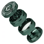 En grøn, cylindrisk grinder med en diameter på 55 mm. Overfladen har en mat finish, og der er indgraveret tekst i hvid farve, der siger "Legalize It". Grinderens top er udstyret med små, skarpe tænder, der er synlige, og den har en skruefunktion til lukning. Bunden har et nettet filter til opsamling af pollen.