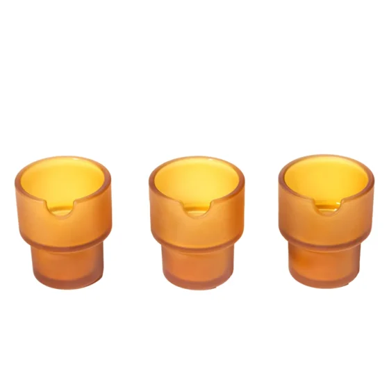 Et askebæger i en honningkageform, fremstillet af klart glas. Overfladen er glat med en hexagonal struktur, der skaber en geometrisk effekt. Askebægeret har en bred, flad bund og en indsnævret top, hvilket giver det stabilitet. Det transparente materiale fremhæver refleksioner og lysgennemtrængning, hvilket giver en elegant udstråling.