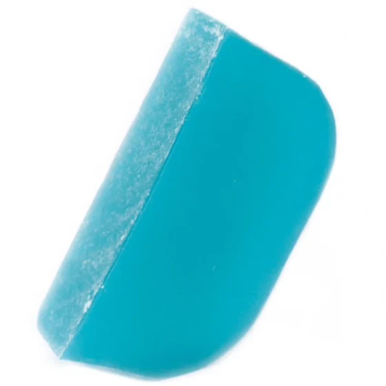 En shampoo bar i en rund form, præsenteret i en naturlig grøn farve, der minder om friske urter. Overfladen har en let tekstureret finish med små ujævnheder og et skinnende glans, der indikerer fugt. Produktet er pakket i en enkel, genanvendelig papemballage med minimalistisk design og tydelig tekst, der beskriver indholdet.