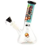 En blå beaker bong med en svampeformet toppet del. Materialet er klart glas med en glat overflade, der reflekterer lys. Bongen har en bred bund, der giver stabilitet, og en slankere hals. Der er en indbygget perkolator og et aftrækkeligt skålområde, som er placeret på siden. De runde kanter giver en blød silhuet til designet.