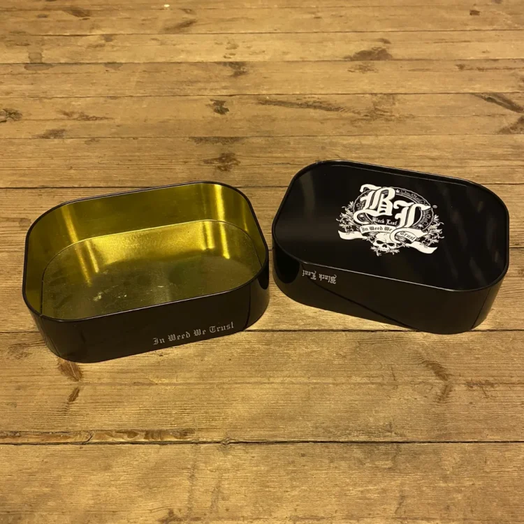 En opbevaringskasse med en sort, mat overflade og en firkantet form. Kassen har bløde, afrundede hjørner og er fremstillet af plastmateriale, der giver en ensartet tekstur. Der er ingen synlige håndtag eller låse, og kassen præsenterer en simpel, funktionel design uden dekorationer. Størrelsen er kompakt, ideel til opbevaring.