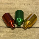 Et konisk bonghoved i metal præsenterer sig med en glinsende overflade, der reflekterer lys. Farven er en dyb grøn, der skaber kontrast mod de skarpe kanter. Hovedets åbning er bredere i toppen og indsnævrer sig mod bunden. Mønstre af små riller pryder overfladen, hvilket tilføjer en struktureret tekstur. Det er designet til at passe sammen med en bong.