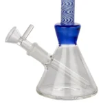En blå bongs struktur fremstår med en glat, transparent overflade, der reflekterer lys og skaber en lysende effekt. Den har en cylindrisk form med en bredere base, der gradvist snævrer ind mod toppen. Detaljer som en krum hals og et lille indsatshul er tydelige. Farven varierer i nuancer fra dyb marineblå til lysere toner, hvilket skaber et dynamisk udtryk.