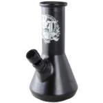 En sort bongs struktur er lavet af glas og har en slank, cylindrisk form med en bredere base. Den har en indviklet stil med et asymmetrisk bladmønster i lysegrønne og gule nuancer, der kontrasterer med den matte overflade. Der er en afrundet mundstykke og en skål, som er placeret på siden. Glasset har en let gennemsigtig kvalitet, der giver en dybde til designet.