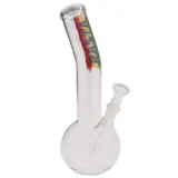 En beaker i rasta farver, der måler 25 cm i højden. Den har en bred, stabil bund og en smal hals, hvilket skaber en karakteristisk form. Overfladen er glat og glasagtig, prydet med farverige mønstre i grøn, gul og rød. En afrundet skål er placeret øverst, og der er en nedadgående rørstruktur, der strækker sig fra halsen.