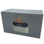 En moderne aroma diffuser præsenterer sig i en slank, cylindrisk form med en glat, mat overflade i en mørk farve. Øverste del er udstyret med et flamme-effekt lys, der skaber en blød, varm glød. En USB-C-port og kontrolknapper er placeret diskret på enheden, og små ventilationsåbninger sikrer luftcirkulation. Diffuseren har en minimalistisk, stilren æstetik.
