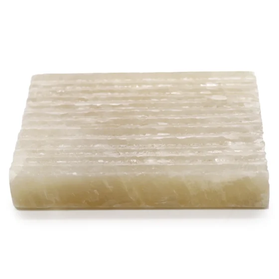 En firkantet skål med en glat overflade fremstillet af honningfarvet marmor. Skålen har en poleret finish, der fremhæver marmorets naturlige årer og nuancer i beige og brun. Kanterne er let afrundede, og bunden er flad, hvilket giver stabilitet. Skålen er designet uden mønstre, hvilket fremhæver det elegante og tidløse udtryk.