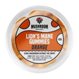 Orange gummies med en blød, glat overflade og en let gennemsigtig kvalitet. De har en rund form med en svag glans, der reflekterer lys. Overfladen prydes af en let sukkerbelægning, der tilføjer en tekstureret dimension. Farven er jævn og intens, hvilket gør dem visuelt tiltalende. Elementerne er arrangeret i en uformel bunke.