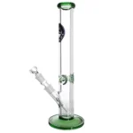 En grøn bong i glas med en høj, slank form. Den har en rund bund og en lige, cylindrisk hals. Der er en indbygget karbongrube og en skarp kant ved åbningen. Overfladen er glat med en let gennemsigtig finish, og der er en dekorativ detalje ved bunden. Farven er ensartet og intens.