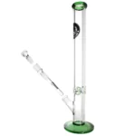 Den grønne bong har en slank, cylindrisk form med en glat overflade. Den er fremstillet af klart glas, der giver en transparent effekt, mens et grønt mønster snor sig op ad siden. En bred base stabiliserer strukturen, og en skål med en buet form er placeret på siden. Der er også en rørformet mundstykke i toppen, der er let udvidet.