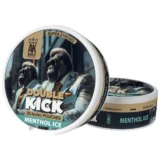 En dobbelt kick menthol is, præsenteret i en klar, cylindrisk beholder med en skridsikker overflade. Beholderen har en opadgående bue og en mat, hvid etiket med sort og grønt tekstdesign. Indholdet er gennemsigtigt med en let blålig farvetone. Låget er fladt og sort, med en tydelig, præcist udformet åbning.