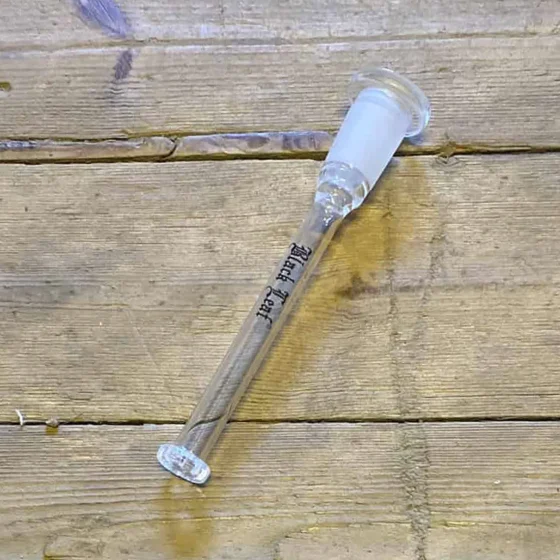 Adapteren har en cylindrisk form med en diameter på 115 mm. Den er sort med en glat overflade og prydes af en subtil tekstur, der giver et stilrent udseende. En diffuser er integreret i designet, og der er tydelige, let buede linjer, der fremhæver adapterens funktion. Kanten er præcist skåret, hvilket sikrer en god pasform.
