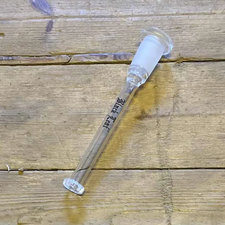 Adapteren har en cylindrisk form med en diameter på 115 mm. Den er sort med en glat overflade og prydes af en subtil tekstur, der giver et stilrent udseende. En diffuser er integreret i designet, og der er tydelige, let buede linjer, der fremhæver adapterens funktion. Kanten er præcist skåret, hvilket sikrer en god pasform.