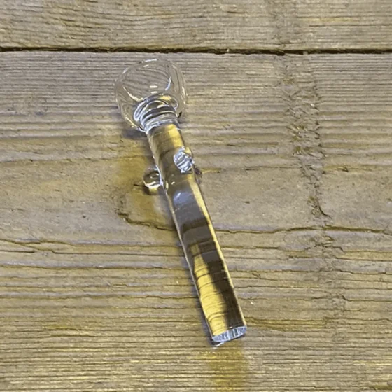 Glasnail i klart glas med en diameter på 50 mm præsenterer en glat og skinnende overflade. Den cylindriske form har en let buet top og en flad bund, hvilket giver stabilitet. Ingen synlige mærker eller dekorative elementer pryder overfladen. Den gennemsigtige struktur skaber en elegant og minimalistisk æstetik, der fremhæver glasmaterialets renhed.