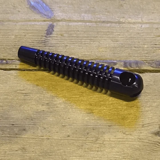 En metalpibe i en dyb lilla nuance med en glat overflade og let refleksion. Piben har en cylindrisk form med en diameter på 60 mm og en ensartet struktur uden synlige samlinger. Enden af piben er flad, mens den anden ende er åben, hvilket giver en ren og moderne finish. Mønstret er minimalistisk og stilrent.