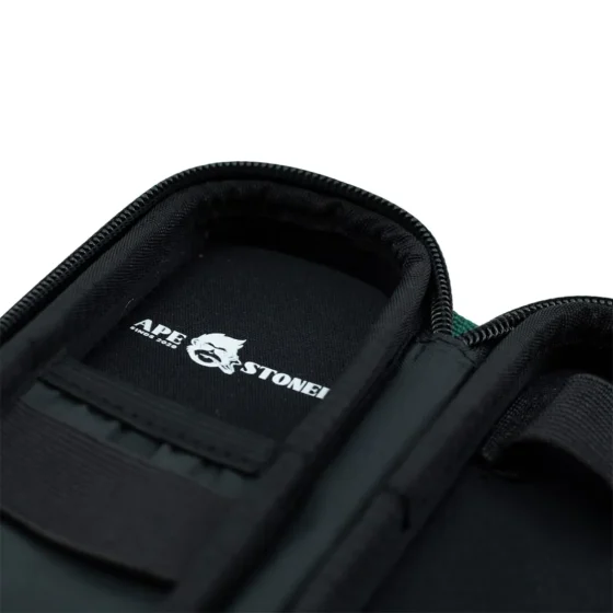 Et slankt, rektangulært etui i en dyb grøn farve præsenterer sig med en mat overflade, der har en let tekstur. Kanten er afrundet, hvilket giver et blødt udtryk. På den ene side er der en subtil logoembossing, mens der på den modsatte side er præcise udskæringer til knapper og porte, der sikrer funktionalitet.