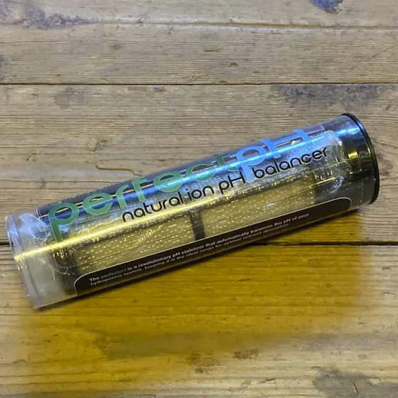 En udstillingsmodel præsenterer en elegant, cylindrisk beholder fremstillet af klart glas. Beholderen har en glat overflade og en skruelåg i børstet metal. Interiøret indeholder flere rør og en pumpemekanisme, der er fremstillet af plast. Farverne er overvejende neutrale, med klare, gennemsigtige elementer og sølvfarvede detaljer, der skaber en moderne og stilren fremtoning.