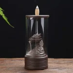 En brænder i form af en drage, fremstillet af keramik med en glat, glinsende overflade. Dragen har detaljerede skalaer og en elegant krop, der slynger sig nedad. Vandfaldene, der strømmer fra dragens mund, har en gennemsigtig og let blåtone, mens den nederste del er dekoreret med små, naturlige klippeformationer. En kombination af farver fra dyb grøn til brun pryder basen.